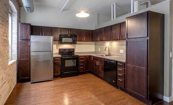 a kitchen with wooden cabinets and stainless steel appliances