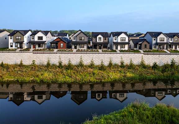 a row of houses reflected in a body of water