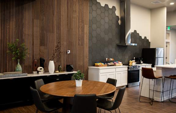 A modern kitchen with a wooden table and chairs.