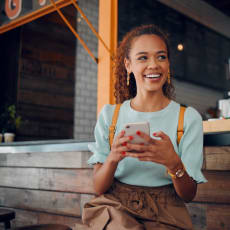 a young woman holding a cell phone in a coffee shop