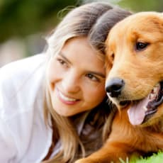 a woman and her dog laying on the grass