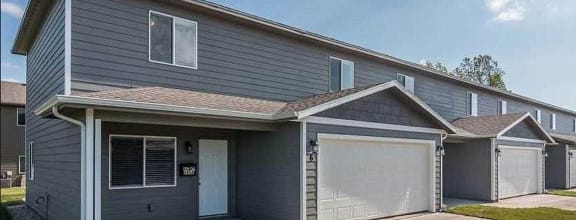 a gray house with a garage on a sunny day