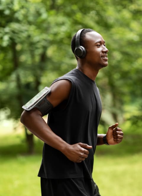 Man Wearing Headphones and Smiling while Jogging