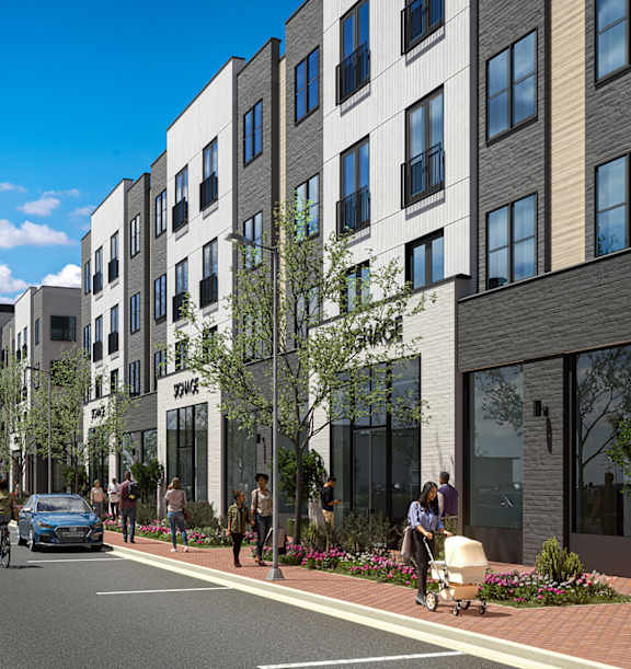 A street view of a residential area with apartment buildings and people walking on the sidewalk.