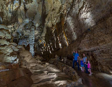 A group of people are exploring a cave with a narrow passage.