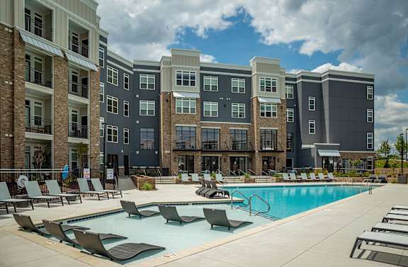 A large swimming pool in front of apartment buildings.