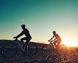 Two People Biking Together During Sunset