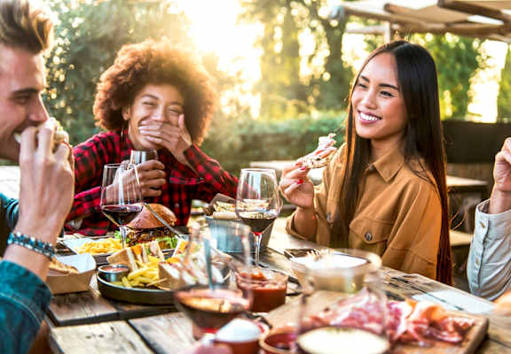 A group of people enjoying a meal together at an outdoor restaurant.