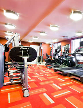 A gym with treadmills, elliptical machines, and a weight machine.