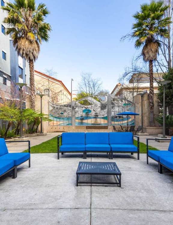 a courtyard with blue couches and a coffee table