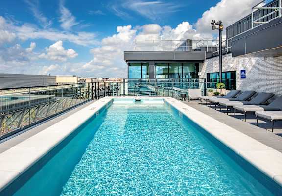 555 Apartments Near The Wharf in Washington, DC Rooftop Pool with Lounge Chairs