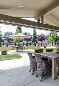 A patio with a table and chairs under a roof.
