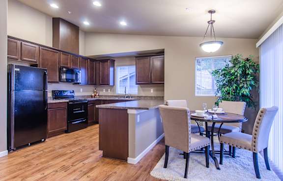 A kitchen with a table and chairs in front of a window.