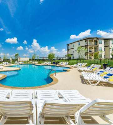 Sparkling swimming pool with lounge chairs at Park 3Eighty in Aubrey, TX 76227