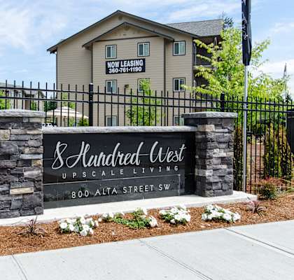 A sign for 8 Hundred West Upscale Living in front of a building.