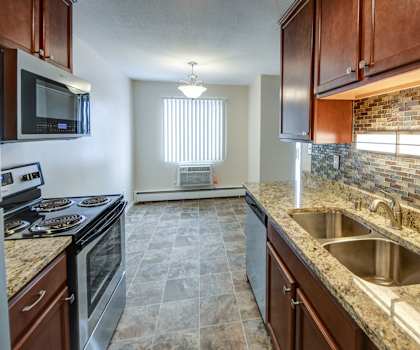 a kitchen with wood cabinets and granite countertops