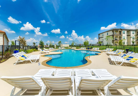 Sparkling swimming pool with lounge chairs at Park 3Eighty in Aubrey, TX 76227