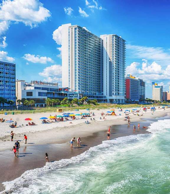 A beach scene with people enjoying the sun and the ocean.