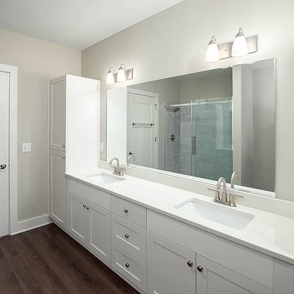 A white bathroom with a sink and mirror.