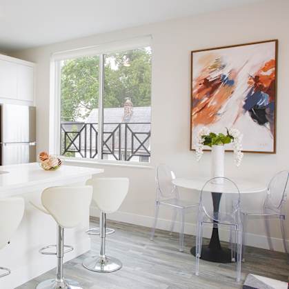a kitchen with white cabinets and a large window