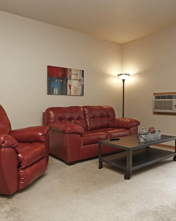 a living room with two leather couches and a coffee table