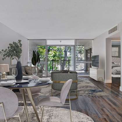 a living room with a table and chairs and a balcony