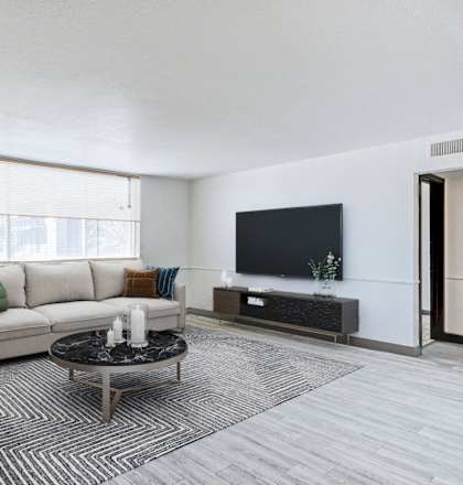 the living room of an apartment with a couch and a tv