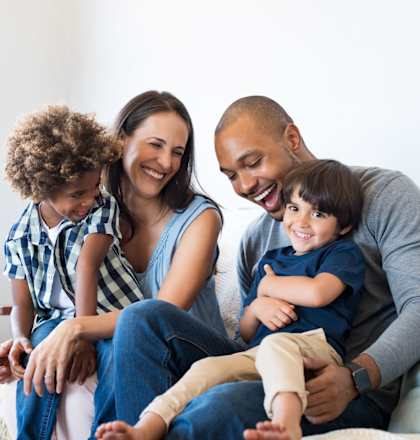 a family sitting on a couch with their children