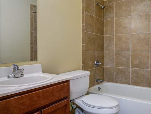 A bathroom with a white toilet, a sink, and a bathtub.
