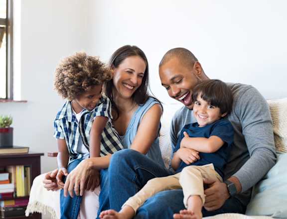 a family sitting on a couch with their children