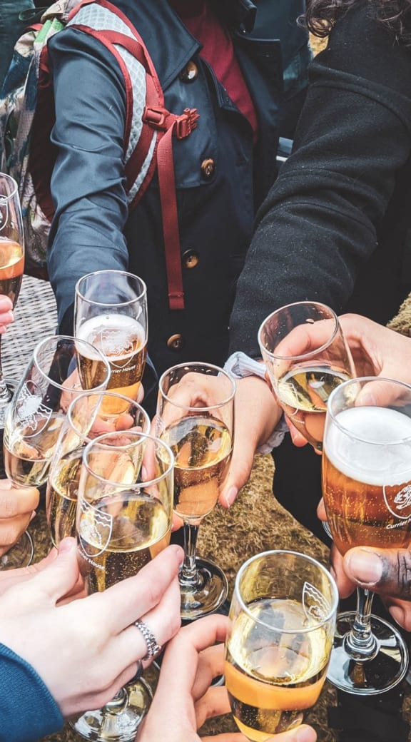 a group of people holding glasses of beer