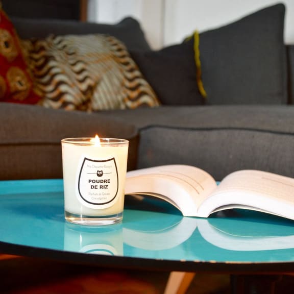 a candle sitting on a table next to an open book