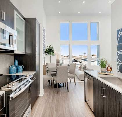 an open kitchen and dining room with a view of a living room