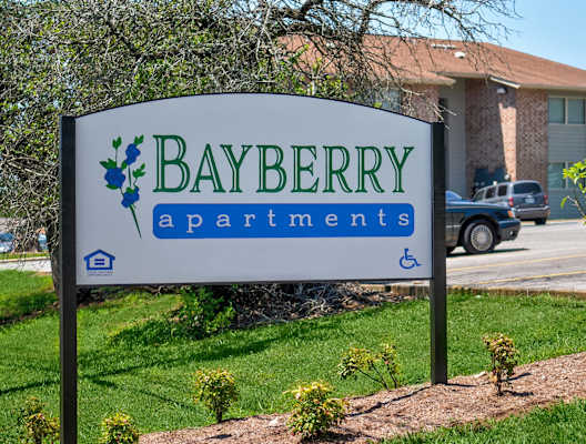 A sign for Bayberry Apartments is shown in front of a building.