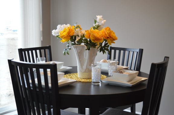 a dining room table with a vase of flowers on top of it