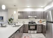 Thumbnail 1 of 8 - A modern kitchen with stainless steel appliances and wooden cabinets.
