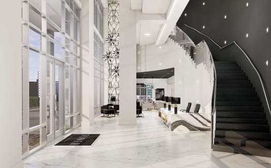 a large lobby with white marble floors and a spiral staircase