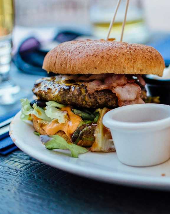 A plate with a burger, fries and sauce.