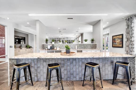 a kitchen with a counter and three bar stools