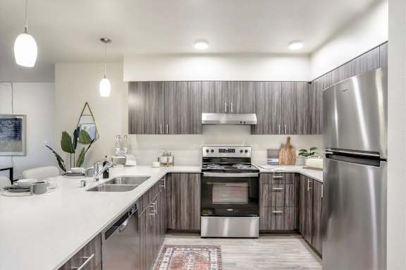 A modern kitchen with stainless steel appliances and wooden cabinets.