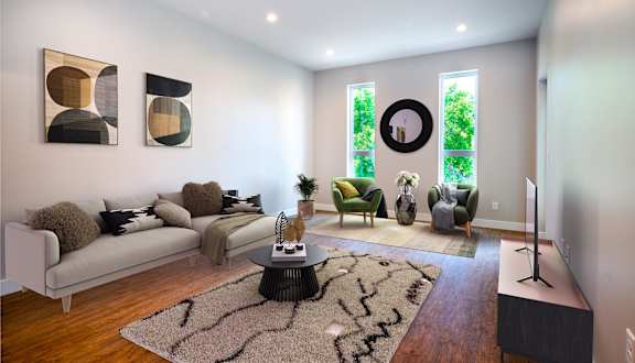 A living room with a white couch, a coffee table, and a rug.