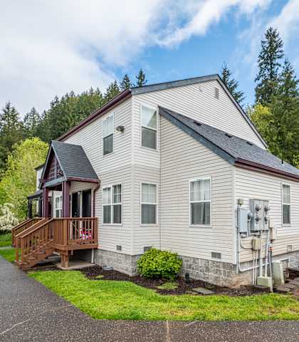 a white house with a porch and a deck on a street
