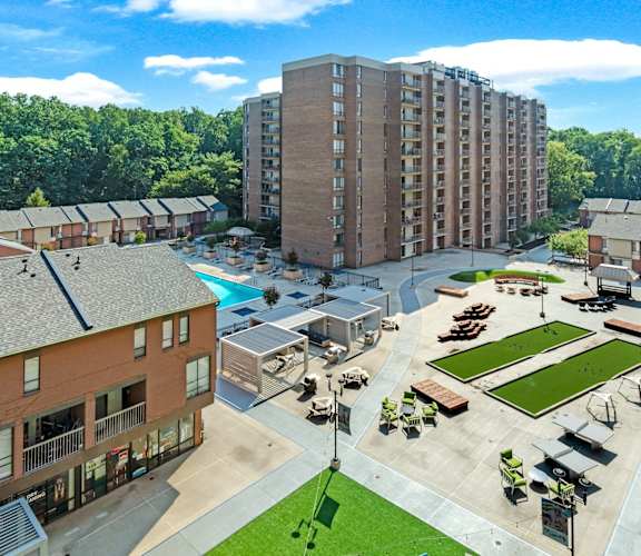 an aerial view of an apartment complex with a swimming pool and lawn
