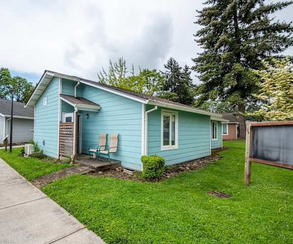 a blue house with a sidewalk in front of it