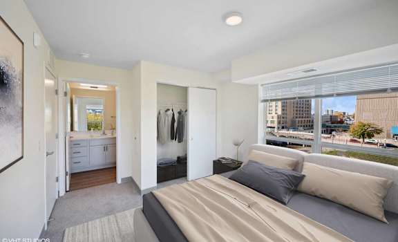 A bedroom with a large bed and a view of the city.