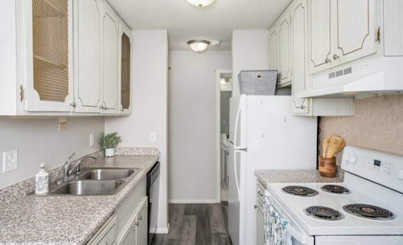 a kitchen with white appliances and granite counter tops