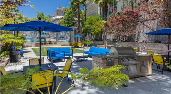 a patio with a grill and tables with umbrellas at K Street Flats, Berkeley California