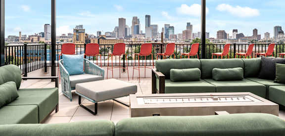 a living room with green couches and chairs and a view of the city