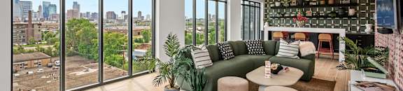 a living room with a green couch and a view of the city