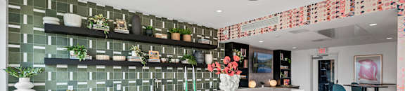 a kitchen with a long white counter and a bar with chairs